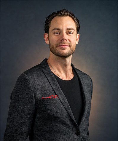 Confident male entrepreneur in a dark blazer, professional headshot for business branding.